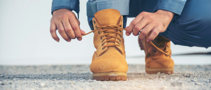 ブーツの靴紐を結ぶ人